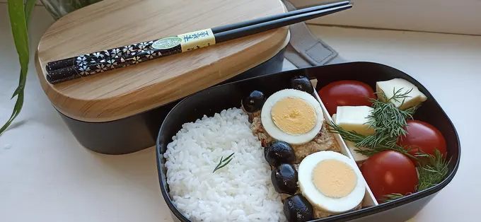 밥, 삶은 달걀, 토마토를 담은 도시락