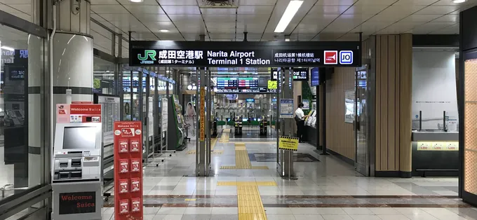 The entrance to JR Narita Airport Terminal 1 Station, with a Welcome Suica vending machine on the left