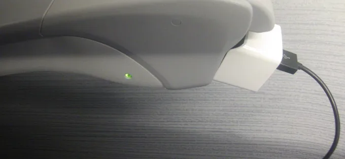 A phone charger plugged into the armrest outlet of a Tokaido Shinkansen N700S seat