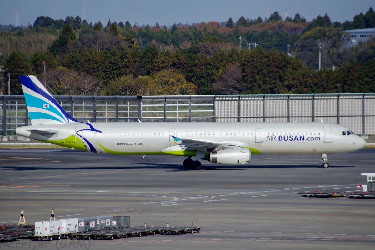 停放在機場停機坪的 Air Busan A321 客機，尾翼有藍綠色漸層標誌