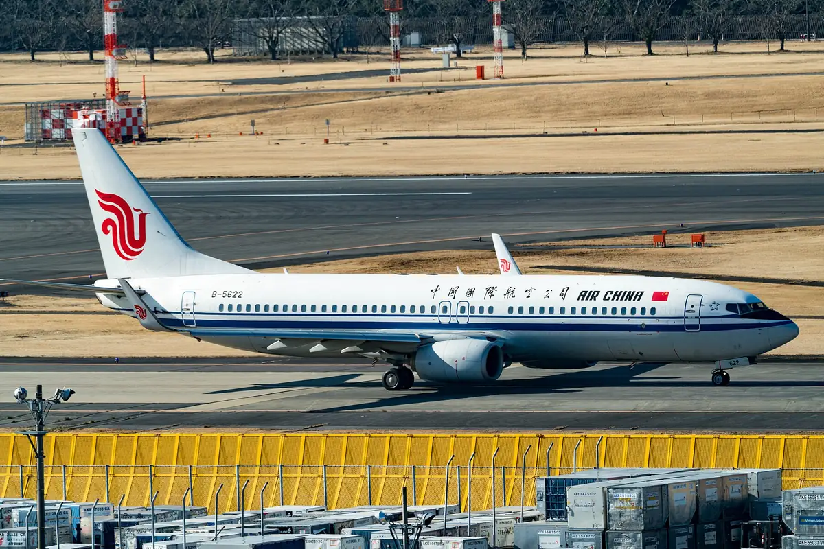 An Air China Boeing 737 aircraft with a red phoenix tail logo on the tarmac at an airport