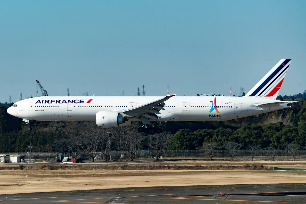 꼬리 날개에 빨간색과 남색 줄무늬, 화려한 파리 로고가 있는 Air France 보잉 777 기종의 공항 착륙