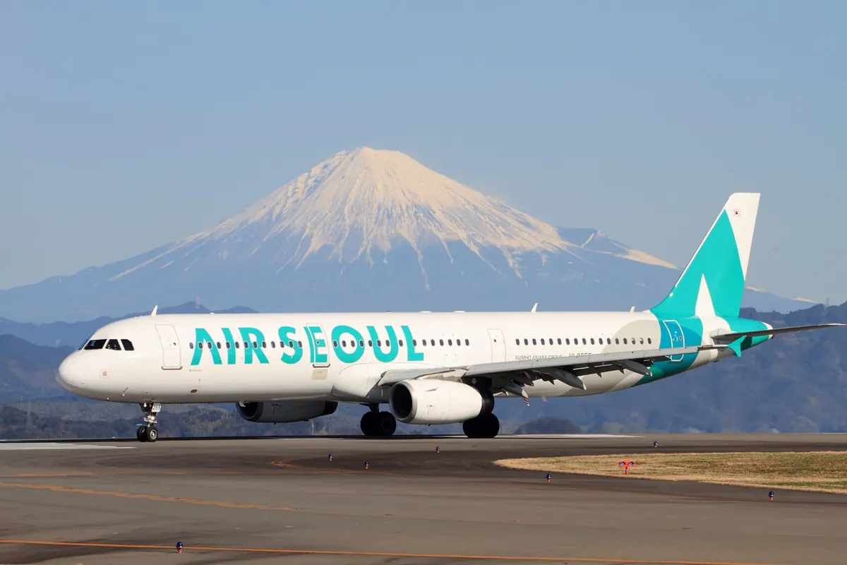 눈 덮인 후지산을 배경으로 시즈오카 공항을 주행하는 Air Seoul A321 기종