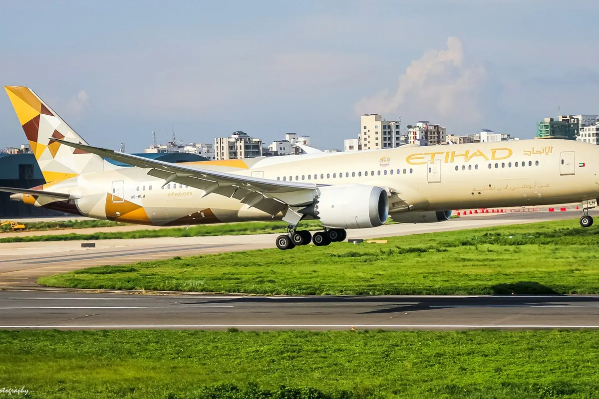 尾翼為金色幾何圖案的 Etihad Airways 波音787客機，以城市建築為背景降落