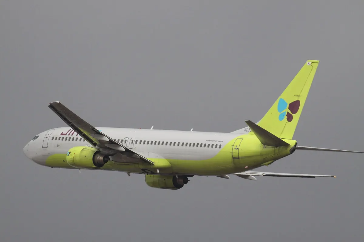 起飛後爬升的Jin Air波音737客機，尾翼為黃綠色並印有蝴蝶標誌