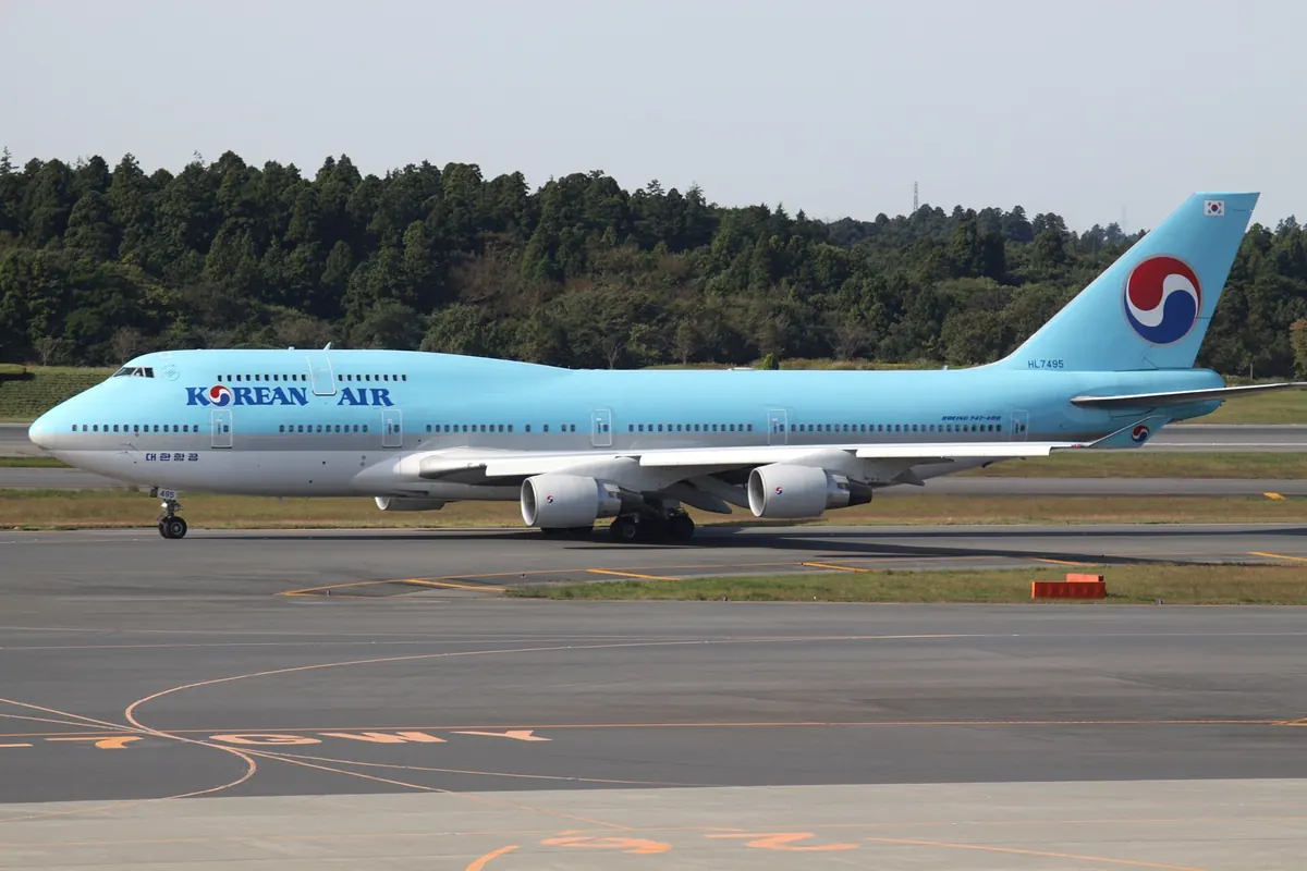成田国際空港を走行する大韓航空のボーイング747型機、背後に木々