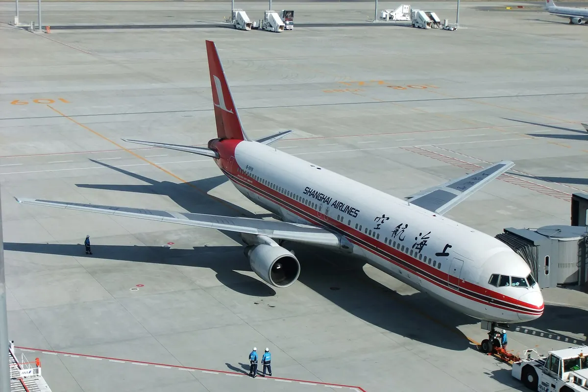 Shanghai Airlines aircraft parked at a terminal gate at Haneda Airport in Tokyo