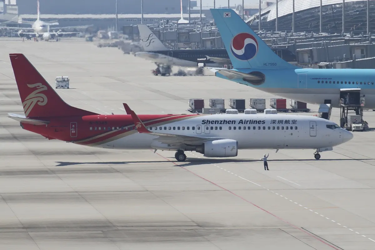 Shenzhen Airlines Boeing 737 aircraft on the airport apron, with a Korean Air aircraft in the background