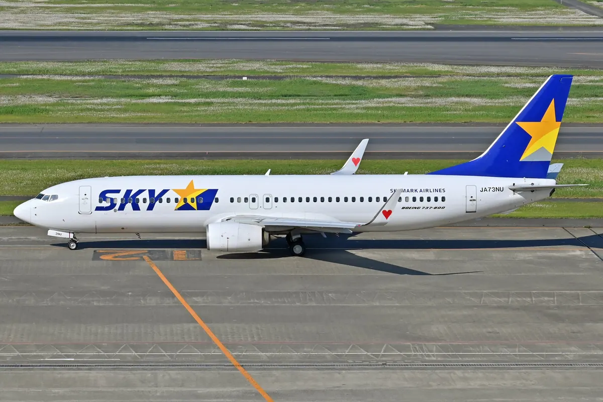 Skymark Airlines Boeing 737 aircraft with a blue and yellow star tail fin taxiing at Haneda Airport
