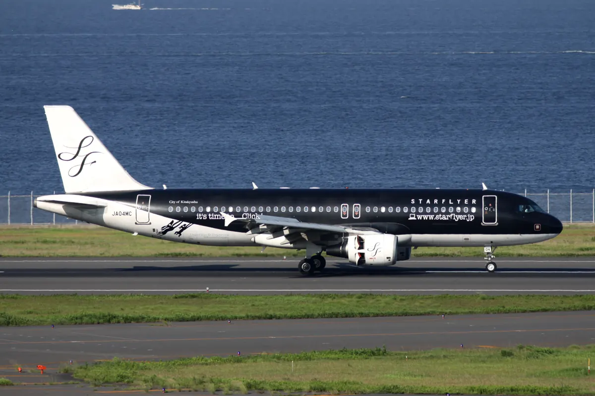 羽田空港で海の近くを走行する黒塗装のスターフライヤーのA320型機