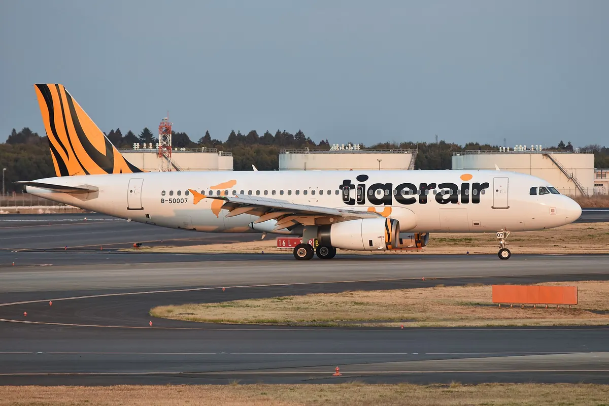 空港の建物の横を走行するタイガーエア台湾のA320型機、尾翼は虎柄
