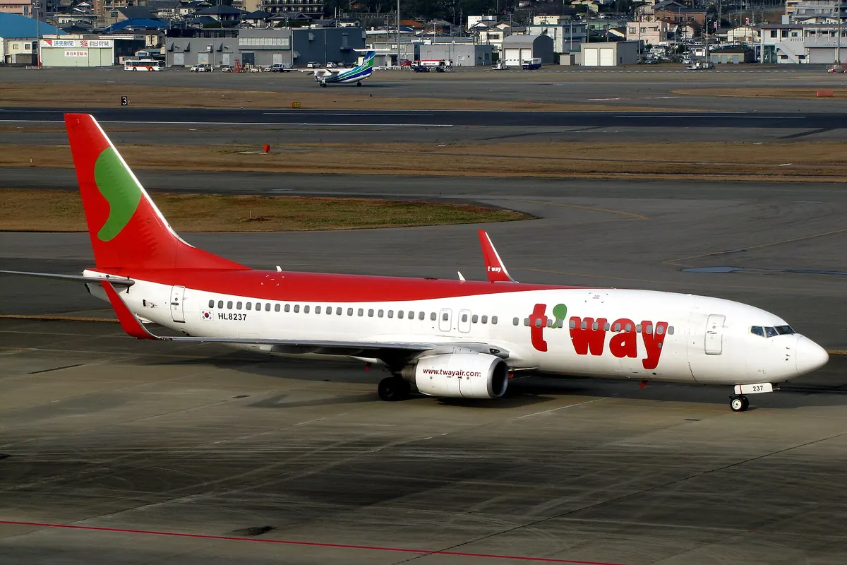 停在福岡機場停機坪的紅白色德威航空（現為 Trinity Airways）波音737-800客機