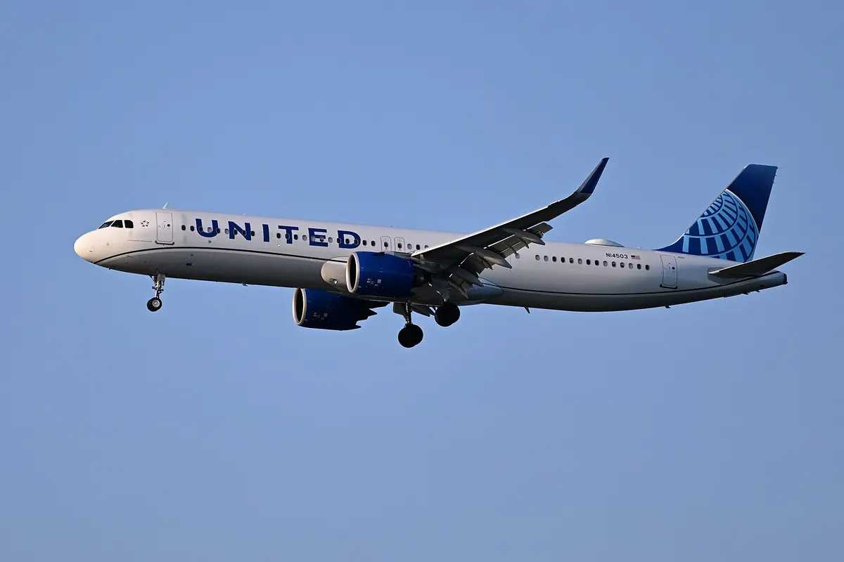 放下起落架正降落的United Airlines A321neo客機，可見藍色尾翼標誌