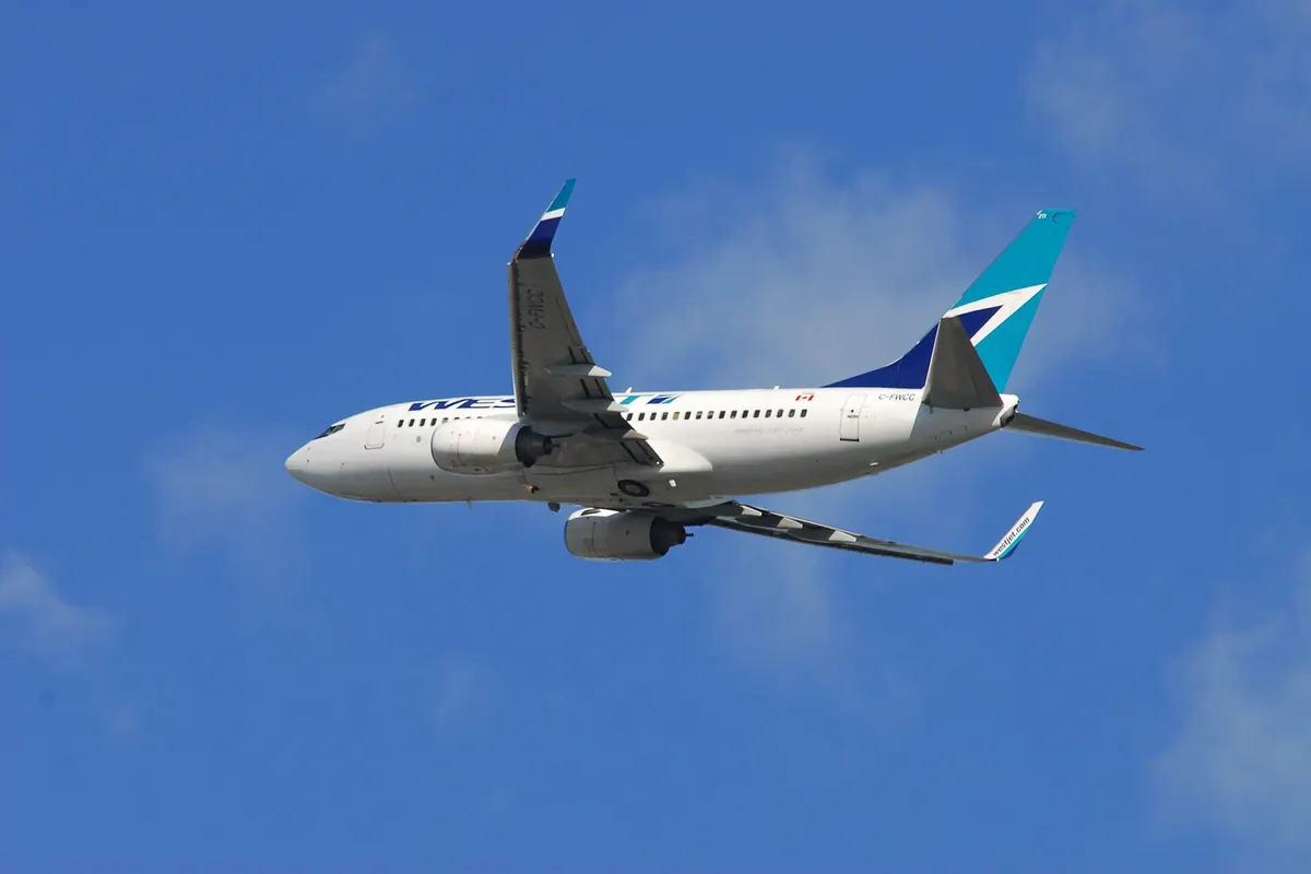 WestJet波音737正在飛行，可見藍色與藍綠色尾翼標誌