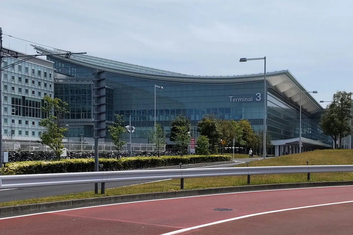 유리 외관과 'Terminal 3' 표지판이 있는 하네다 공항 제3터미널 건물 외관