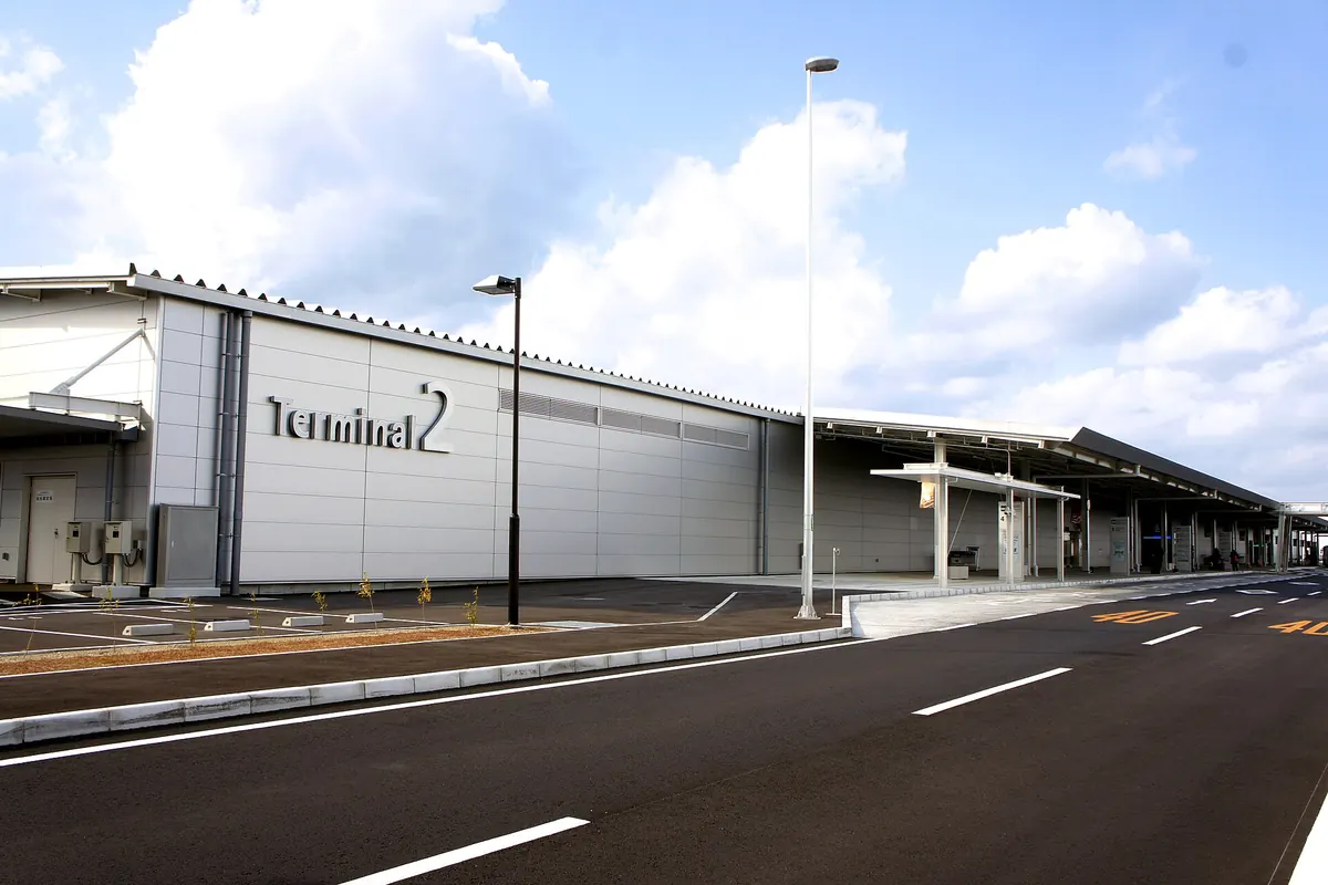 벽면에 'Terminal 2' 표지판이 있는 간사이 공항 제2터미널 건물 외관