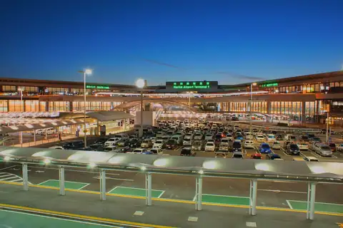 Exterior of Narita Airport Terminal 1 building illuminated at night with the parking lot in front