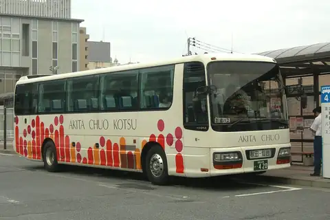 A cream-coloured Akita Chuo Kotsu coach with red and orange dot patterns parked at a bus terminal