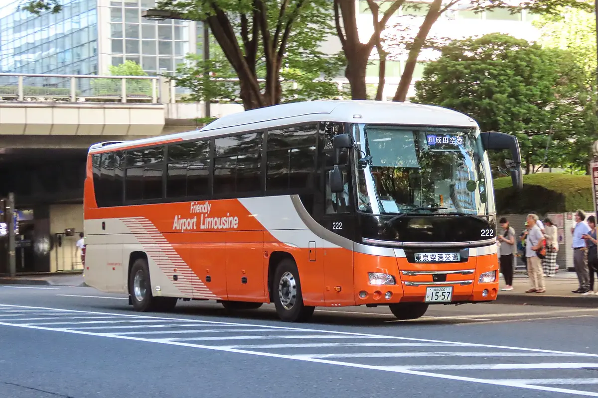 东京新宿街道上，带有目的地显示牌的橙白色利木津巴士
