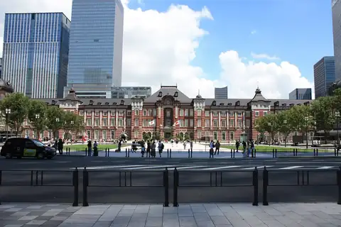 Tokyo Station's red-brick Marunouchi building with domed towers, seen across the road