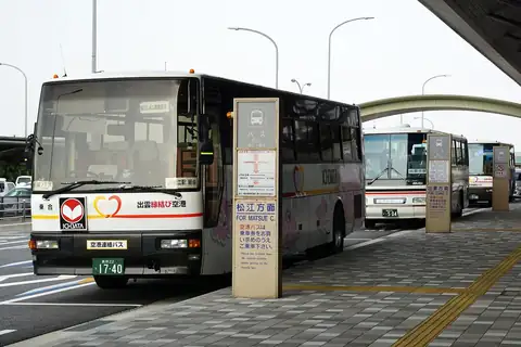 Airport buses parked at the bus stop outside Izumo Airport, with signs for Matsue and Izumo