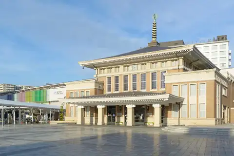 The former JR Nara Station building with a pagoda-style spire, now a tourist information centre, facing a paved plaza