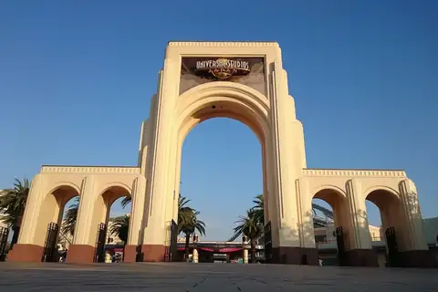 Entrance gate of Universal Studios Japan with a tall central arch and palm trees behind it