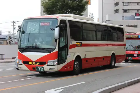 A red and cream Hokutetsu coach bus with a Kanazawa to Toyama route display on a city street