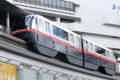 A white and grey Okinawa Yui Rail monorail train with a red stripe at Kencho-mae Station in Naha