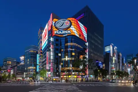 Ginza street corner at night with the Fujiya building and its lit billboards in Tokyo