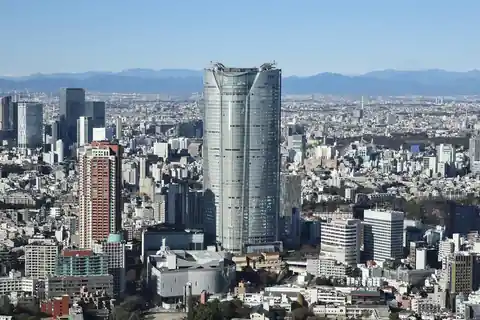 Roppongi Hills tower rising above a dense city, seen from Tokyo Tower