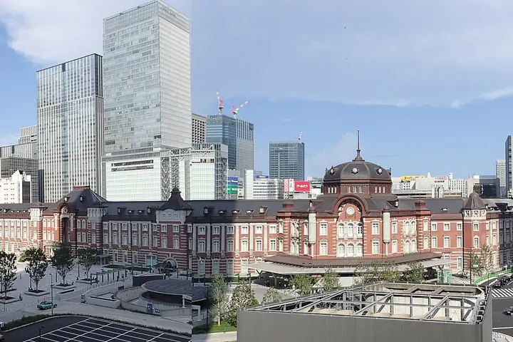Tokyo Station's red-brick Marunouchi building with its central dome and skyscrapers behind it