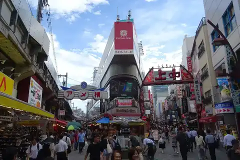Crowds of shoppers on the Ameyoko shopping street in Ueno, Tokyo, under a red arch sign