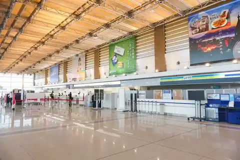 Check-in counters with a wood-paneled ceiling inside Hakodate Airport terminal building