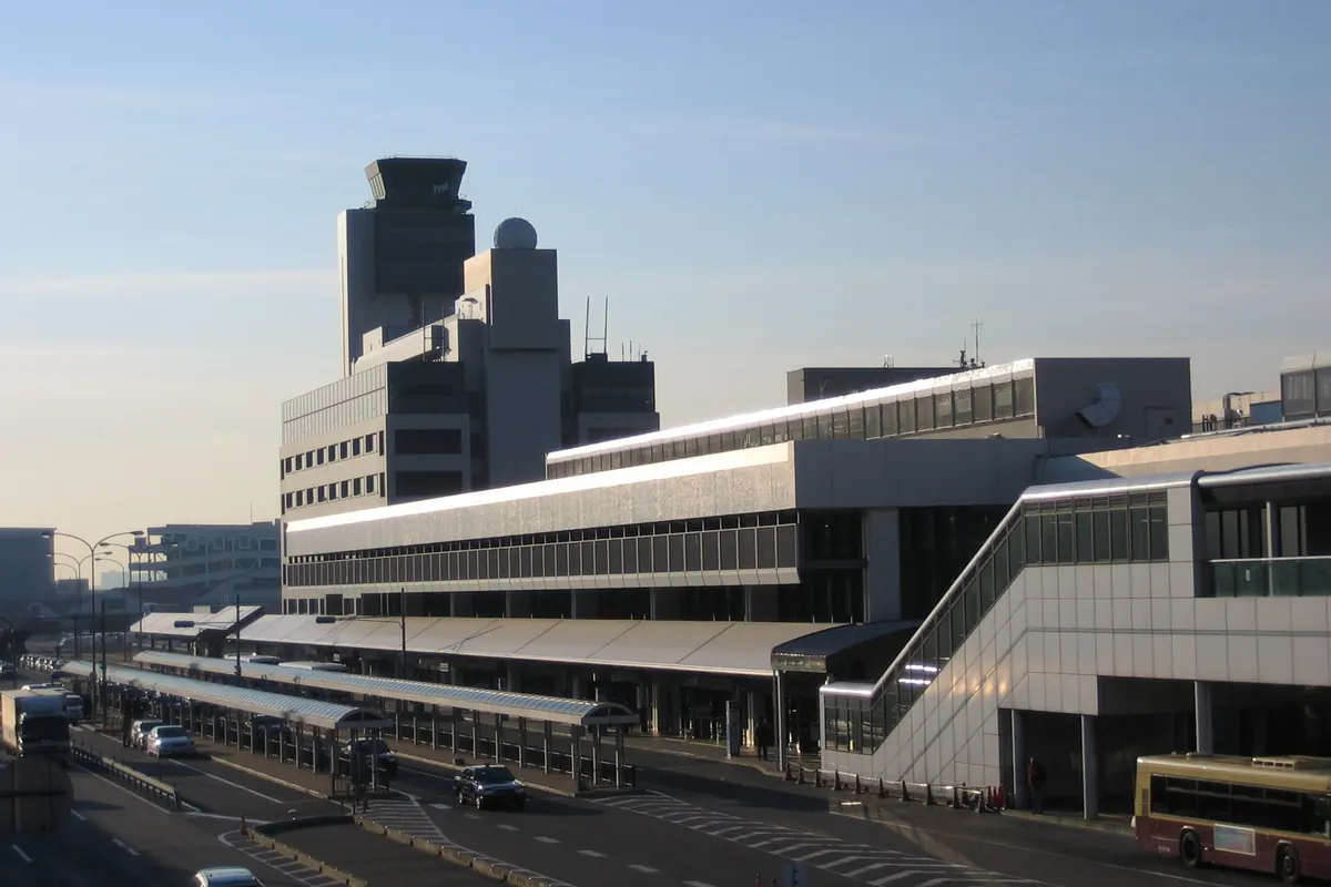 管制塔と外に停まるバスがある伊丹空港ターミナルビルの外観