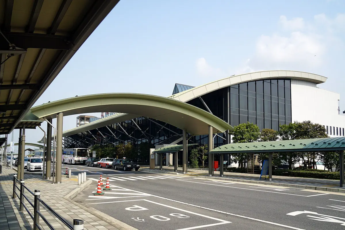 曲線の屋根と外に停まるバスがある出雲空港ターミナルビルの外観