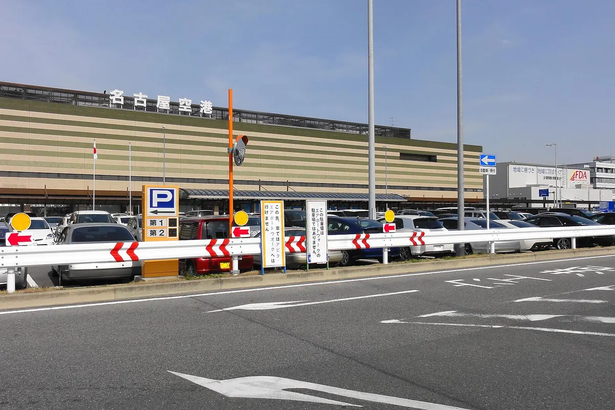 名古屋机场航站楼,位于设有指示标志与护栏的停车场后方