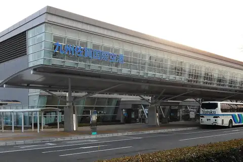 Exterior of Kyushu Saga International Airport terminal building with a large canopy and a bus on the road