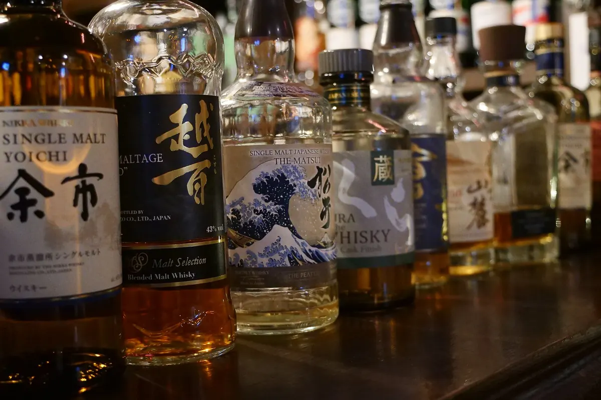 Rows of Japanese whisky bottles lined up on a bar counter