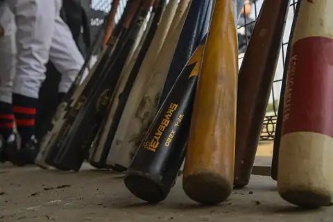 Baseball bats leaning together in a dugout during a youth baseball game in Japan