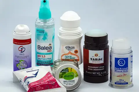 A collection of deodorant products including spray bottles, a roll-on, and stick deodorants