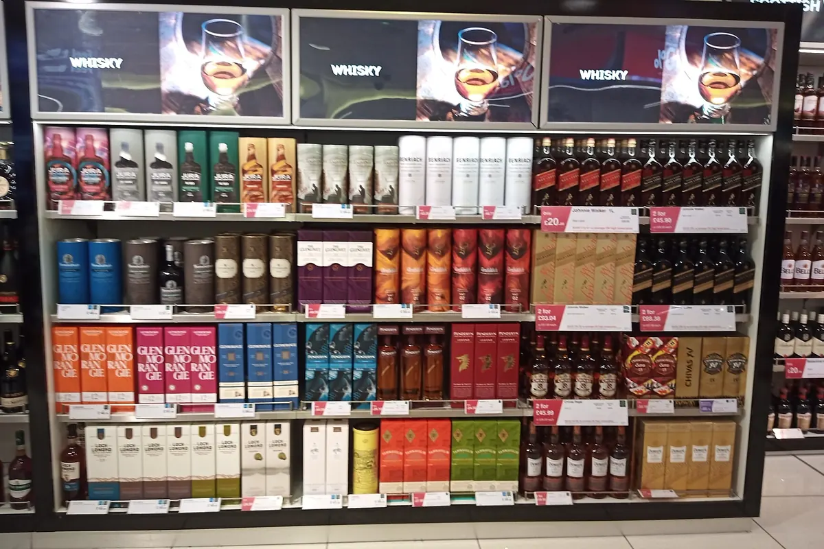 机场免税店内摆满威士忌酒瓶与礼盒的货架