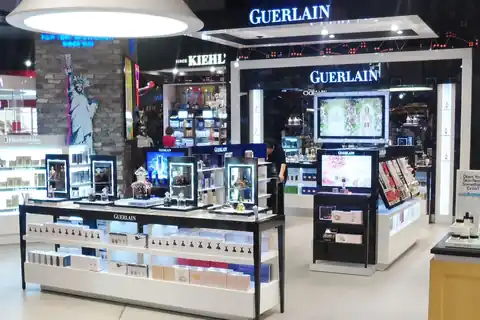 A Guerlain perfume counter with glass display cases in an airport duty-free shop