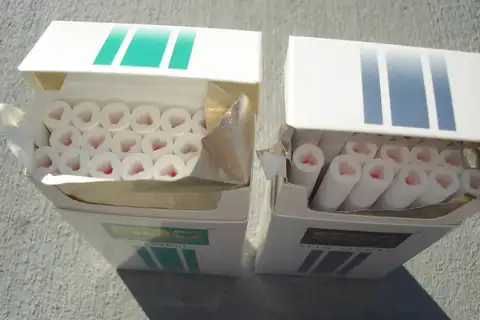Two open cigarette packs with the filters of several cigarettes visible