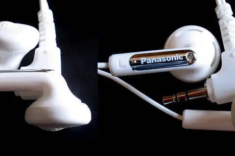 Close-up of white wired earphones showing the earbud tip and the 3.5mm jack with cable