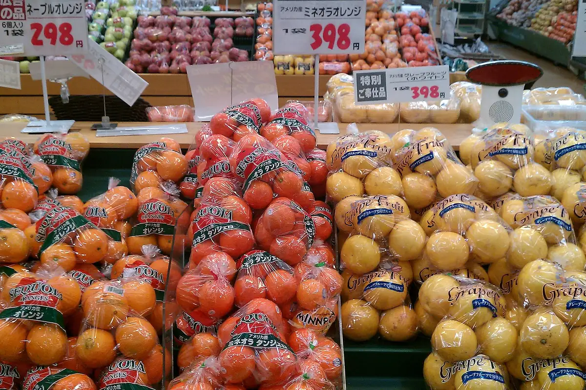 Oranges, mandarins, and grapefruit in mesh bags on display in a Japanese supermarket with price tags
