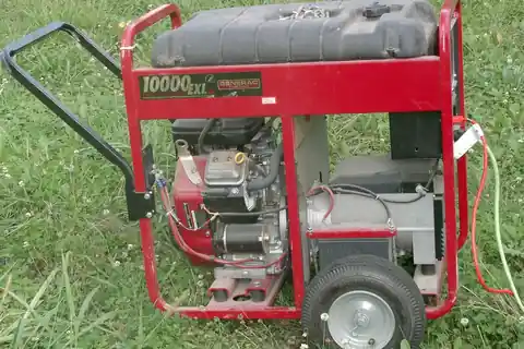 A red-framed portable generator labeled Generac 10000 EXL, with wheels and a handle, standing on grass