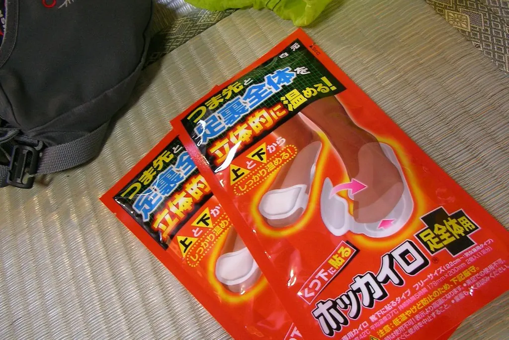畳の上に置かれた赤いパッケージの日本の足用カイロ2袋