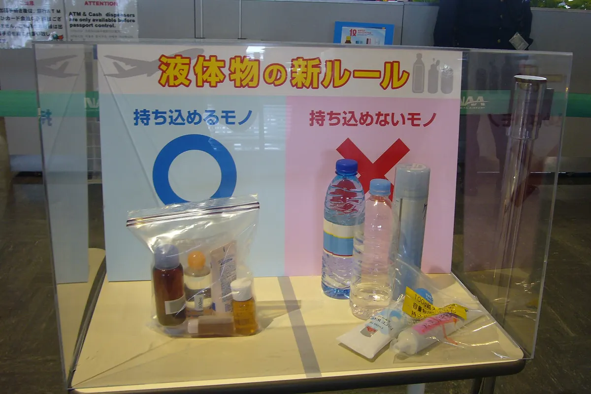 透明展示柜放着装有小瓶液体的密封袋，旁边有日文告示说明新的液体规定
