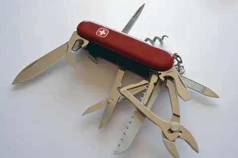 Red Swiss Army knife opened to show its blades, scissors, saw, pliers and corkscrew